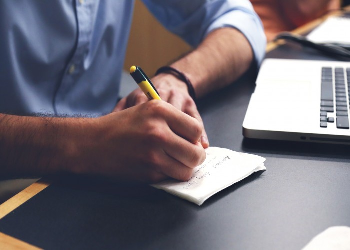 man with laptop making note on training course